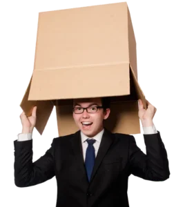Man in a suit smiling while putting a cardboard box over his head