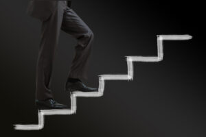 Businessman climbing stairs against a black background, symbolizing professional progress in the USA